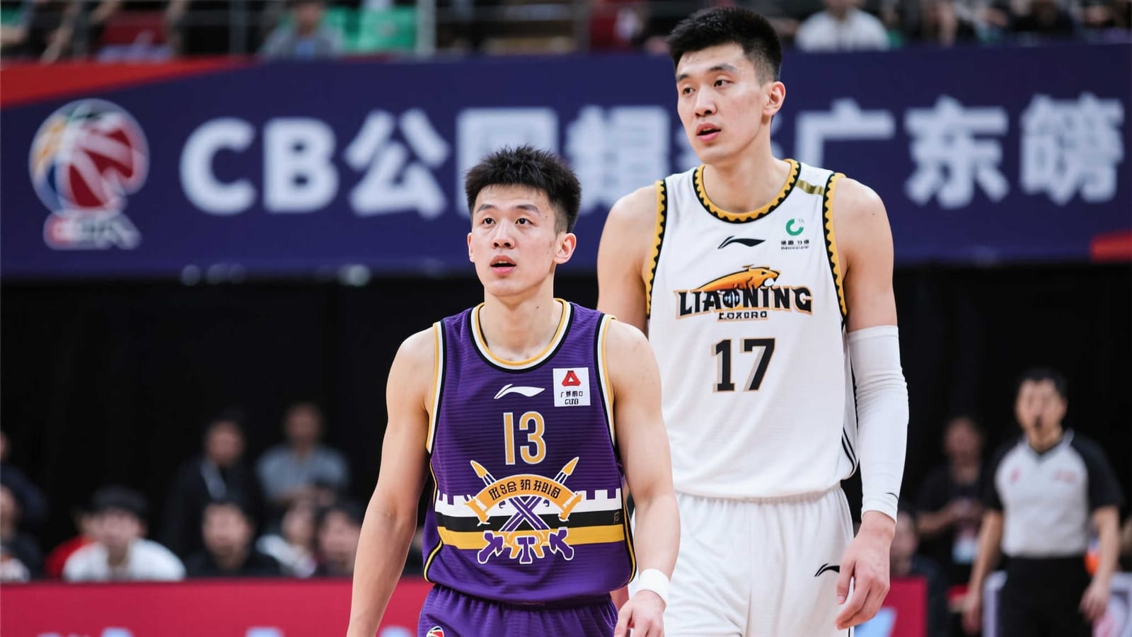足球比赛现场，球员在灯光下争夺控球权